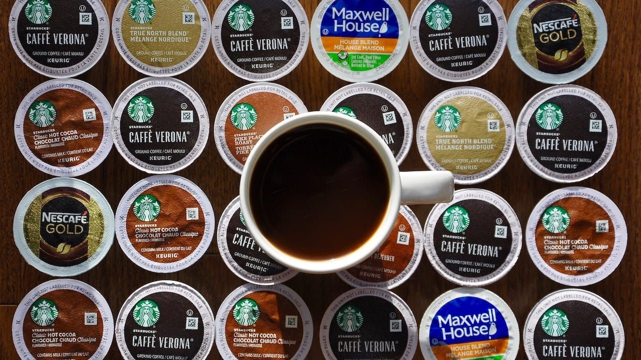 A cup of coffee on top of assorted Keurig k-cup pods.