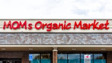 Exterior facade of Mom's Organic Market store with farm fresh produce on street