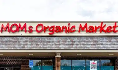 Exterior facade of Mom's Organic Market store with farm fresh produce on street