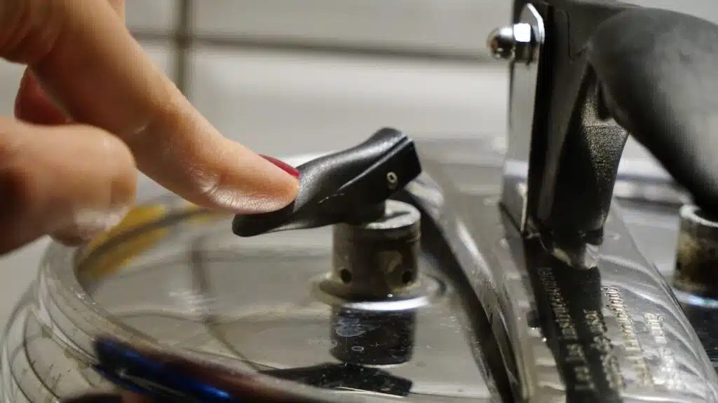 Woman depressurizing pressure cooking pushing on the safety valve