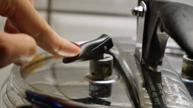 Woman depressurizing pressure cooking pushing on the safety valve