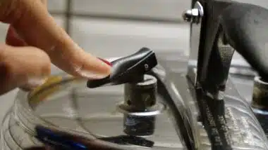 Woman depressurizing pressure cooking pushing on the safety valve