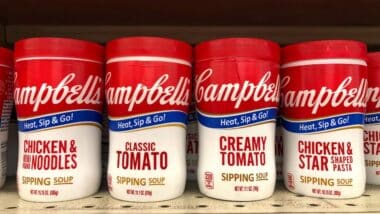 shelf with containers of Campbell's Chicken Noodle, Chicken Stars, Classic and Creamy tomato Soups in convenient to go cups. Microwavable