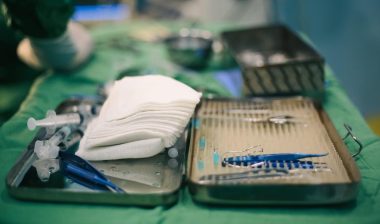 Equipment medical instruments in steel tray for nurse or doctor surgical on green fabric table.