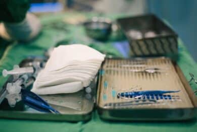 Equipment medical instruments in steel tray for nurse or doctor surgical on green fabric table.