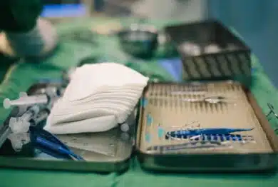 Equipment medical instruments in steel tray for nurse or doctor surgical on green fabric table.