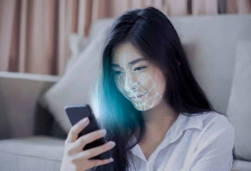 Asian female using mobile smartphone scanning face