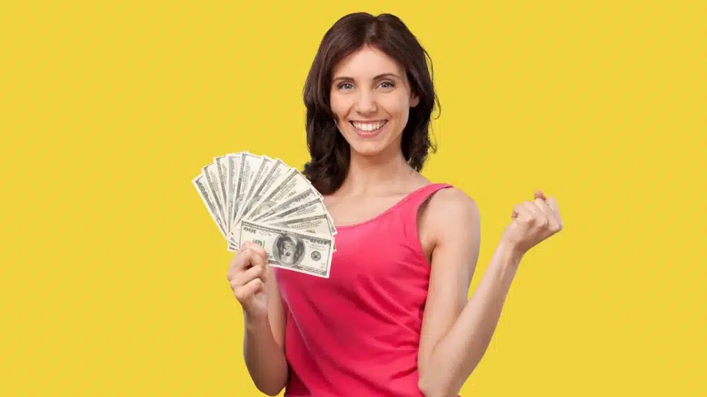 Young happy smart rich woman hold in hand cash money