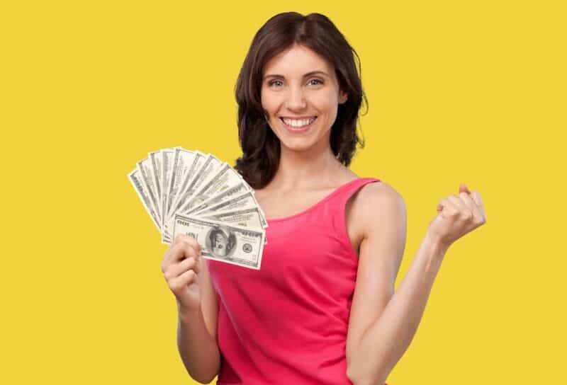 Young happy smart rich woman hold in hand cash money