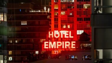 The iconic red neon Hotel Empire sign at night.