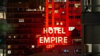 The iconic red neon Hotel Empire sign at night.