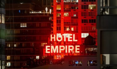 The iconic red neon Hotel Empire sign at night.