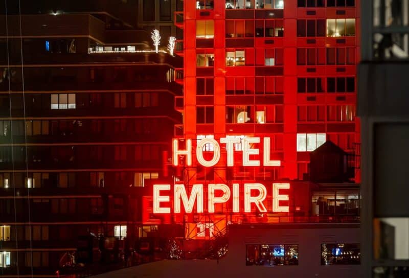 The iconic red neon Hotel Empire sign at night.