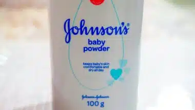 Close up image of white bottle of Johnson's baby powder isolated on table.