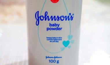 Close up image of white bottle of Johnson's baby powder isolated on table.
