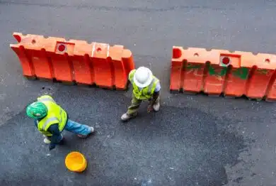 Overview of two construction workers with reflective vest and helmets on a street in New York City, USA