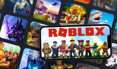Roblox mobile game app on smartphone screen with the game blurred on background.