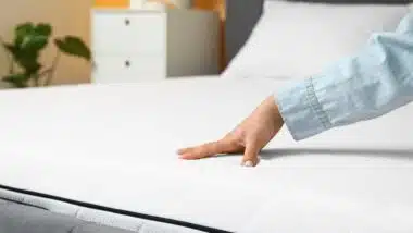 Woman touching soft orthopedic mattress