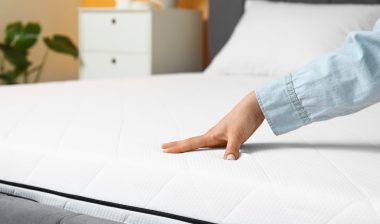 Woman touching soft orthopedic mattress