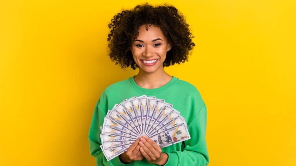 Photo of cheerful pretty lady hold demonstrate usd banknotes