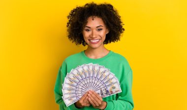 Photo of cheerful pretty lady hold demonstrate usd banknotes