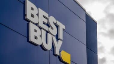 The exterior of a Best Buy store featuring the prominent white "BEST BUY" lettering and yellow tag logo against a dark blue facade.