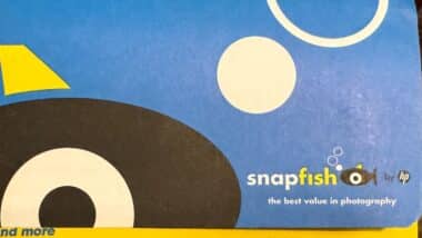 Hand holds a package of SnapFish brand printed photos