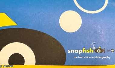 Hand holds a package of SnapFish brand printed photos