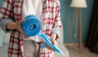 woman hands holding blue roll of plastic garbage bag