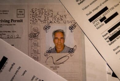 A document from the U.S. Department of Justice release of the Jeffrey Epstein files, showing Jeffrey Epstein, is seen photographed on a desk.