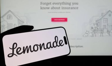Smartphone displaying US insurtech company Lemonade logo in front of companys webpage