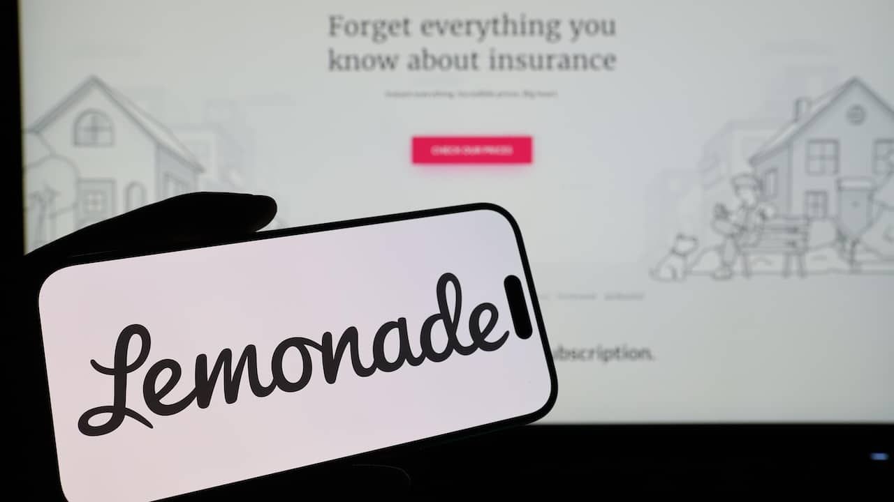 Smartphone displaying US insurtech company Lemonade logo in front of companys webpage