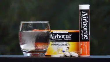 Airborne vitamin supplement tablet dissolving in glass of water.
