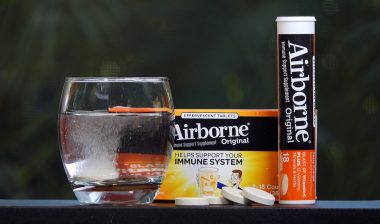 Airborne vitamin supplement tablet dissolving in glass of water.