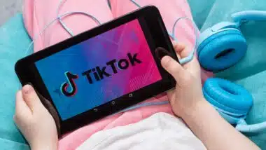 tablet in kids hands with Tik Tok icon on the screen.
