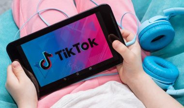 tablet in kids hands with Tik Tok icon on the screen.