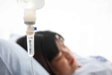 woman lying on a hospital bed, the doctor gives saline solution. Obesity, diabetes, high blood pressure, health problems.