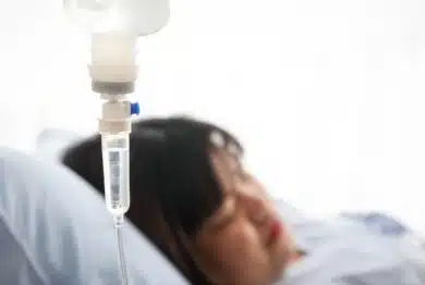 woman lying on a hospital bed, the doctor gives saline solution. Obesity, diabetes, high blood pressure, health problems.