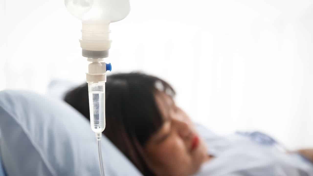 woman lying on a hospital bed, the doctor gives saline solution. Obesity, diabetes, high blood pressure, health problems.