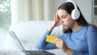 Frustrated woman wearing headphone canceling auto renewal subscription