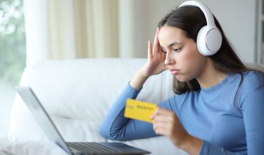 Frustrated woman wearing headphone canceling auto renewal subscription