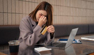 Asian woman stressed over credit card debt