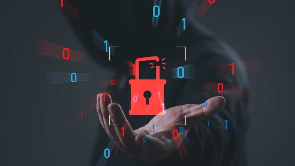 Cybersecurity breach concept with broken padlock and binary code over hooded hacker background, symbolizing data breach