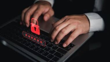 Businessman typing on laptop with red padlock and password graphic for cybersecurity data breach warning