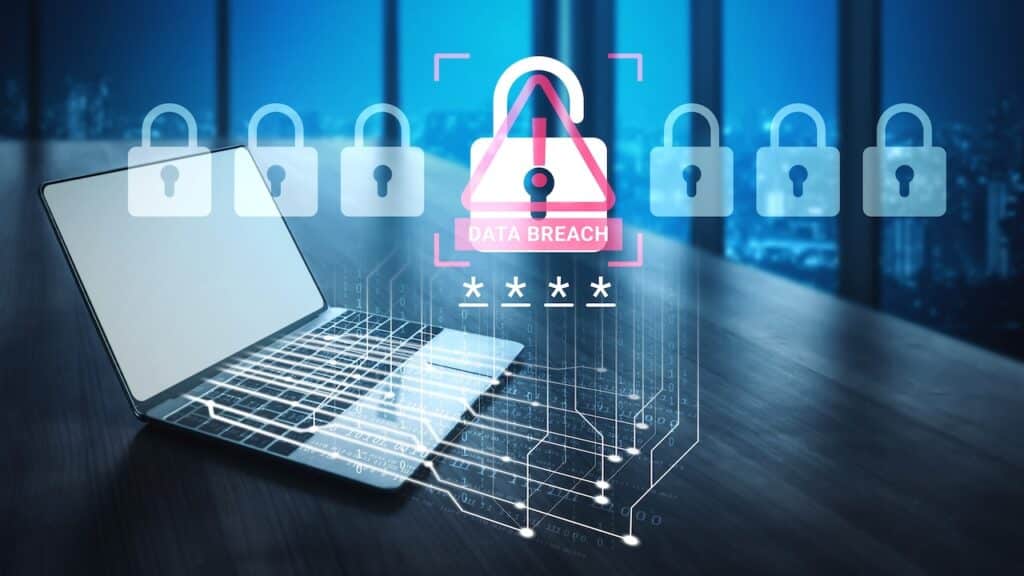 A laptop sits in a modern office, showcasing a digital alert for data breach with lock visuals, emphasizing cybersecurity and the importance of protecting sensitive information