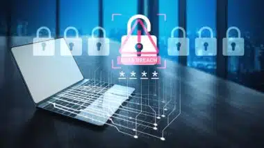 A laptop sits in a modern office, showcasing a digital alert for data breach with lock visuals, emphasizing cybersecurity and the importance of protecting sensitive information
