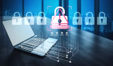 A laptop sits in a modern office, showcasing a digital alert for data breach with lock visuals, emphasizing cybersecurity and the importance of protecting sensitive information