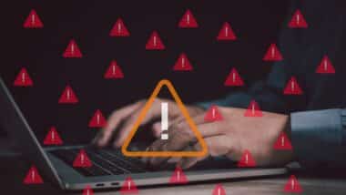 man works on a laptop surrounded by red warning icons, symbolizing cybersecurity threats