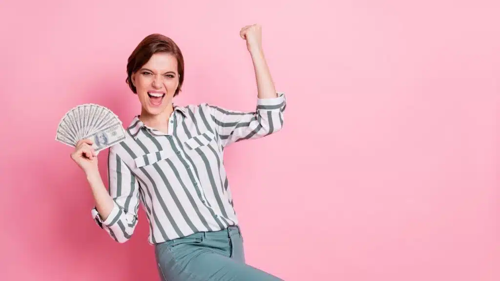 Portrait of cheerful delighted girl hold money fan
