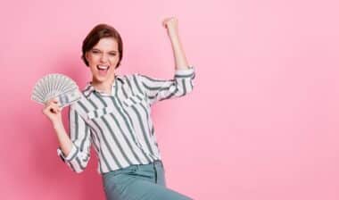 Portrait of cheerful delighted girl hold money fan